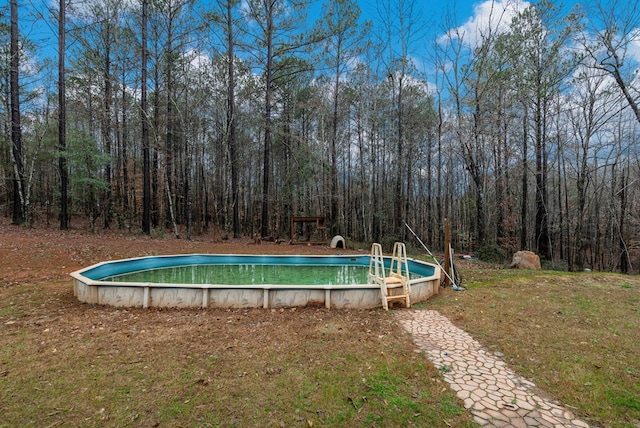 view of pool featuring a lawn