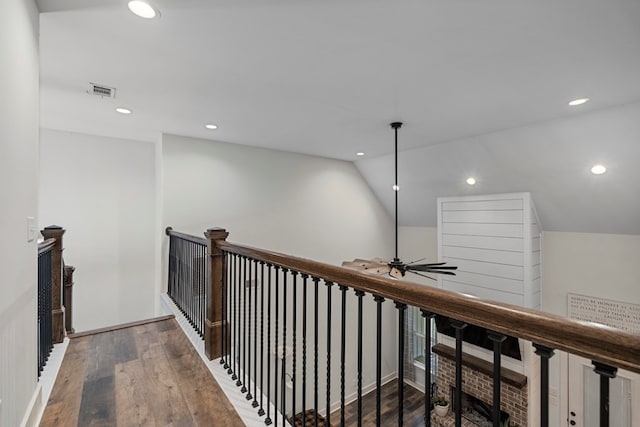 corridor featuring hardwood / wood-style flooring and vaulted ceiling