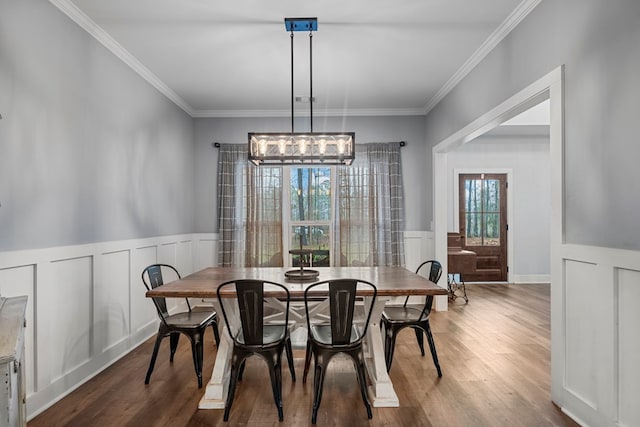 dining area with hardwood / wood-style flooring and crown molding