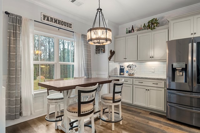 kitchen with pendant lighting, backsplash, ornamental molding, dark hardwood / wood-style flooring, and stainless steel fridge with ice dispenser