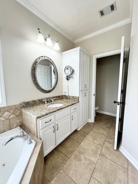 986 Timber Creek Way, Columbus, GA 31904 - bathroom featuring a whirlpool tub, vanity, ornamental molding, tile patterned floors, and a textured ceiling