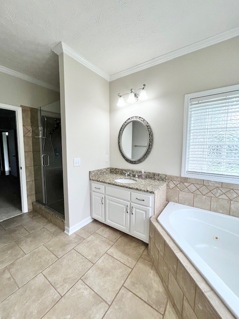 986 Timber Creek Way, Columbus, GA 31904 - bathroom featuring vanity, a tub with jets, ornamental molding, a stall shower, and tile patterned flooring