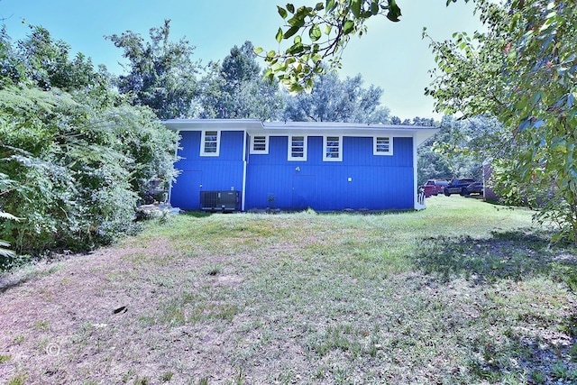 back of house featuring a lawn and cooling unit