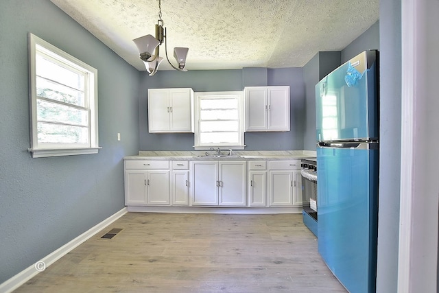 kitchen with hanging light fixtures, white cabinetry, black range with electric stovetop, and stainless steel refrigerator