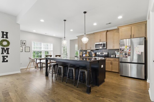 492 Mulberry Crossing Dr, Cataula, GA 31804 - kitchen with stainless steel appliances, dark countertops, a breakfast bar area, dark wood-style flooring, and recessed lighting