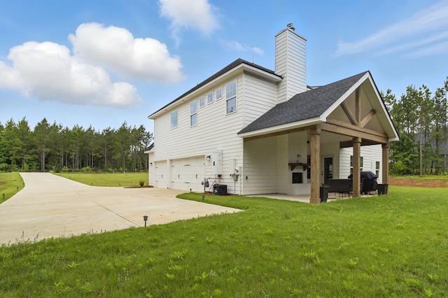 492 Mulberry Crossing Dr, Cataula, GA 31804 - back of house featuring an attached garage, concrete driveway, a yard, a chimney, and roof with shingles