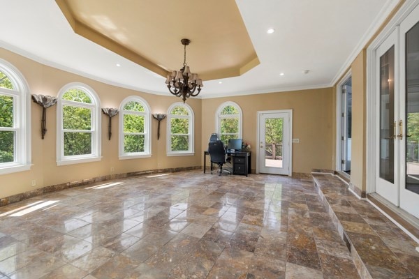 interior space featuring a chandelier, plenty of natural light, french doors, and a tray ceiling