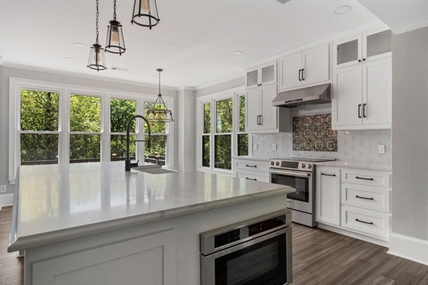 kitchen with white cabinetry, sink, an island with sink, and stainless steel appliances