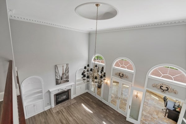 living room with plenty of natural light, wood-type flooring, a fireplace, and a high ceiling