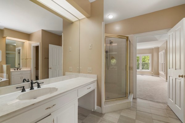 bathroom featuring tile patterned flooring, vanity, and an enclosed shower