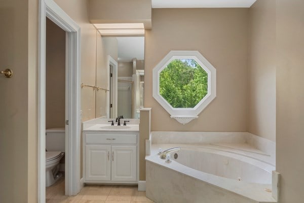 bathroom with a tub, tile patterned flooring, vanity, and toilet