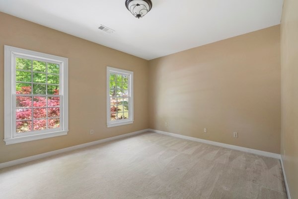 spare room featuring light colored carpet