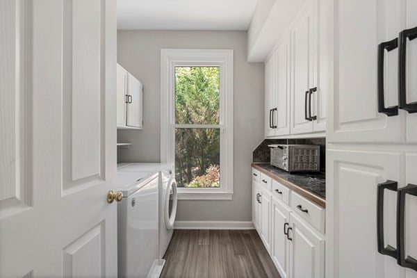 laundry room with washer and dryer, dark wood-type flooring, and cabinets