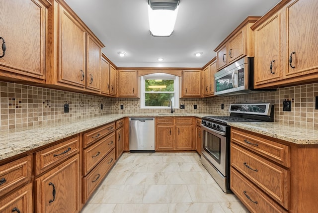 4001 Savannah Dr, Columbus, GA 31907 - kitchen with stainless steel appliances, brown cabinetry, light marble finish flooring, and light stone countertops
