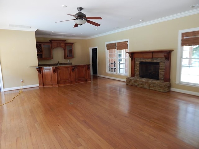 5110 Midland Trce, Columbus, GA 31820 - unfurnished living room featuring baseboards, light wood finished floors, a stone fireplace, crown molding, and a ceiling fan