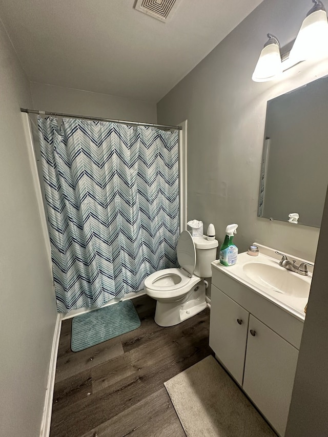 bathroom featuring vanity, hardwood / wood-style floors, toilet, and a shower with shower curtain