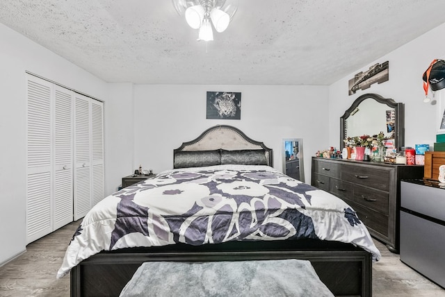 5407 Maltese Dr, Columbus, GA 31904 - bedroom featuring a closet, light wood-style flooring, a textured ceiling, and a ceiling fan