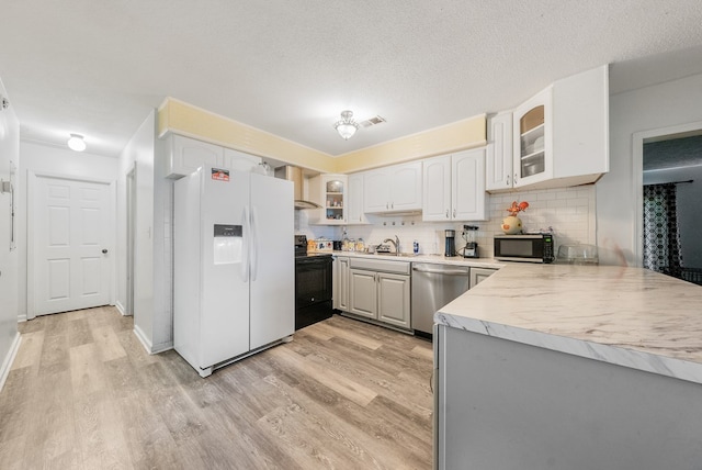 5407 Maltese Dr, Columbus, GA 31904 - kitchen with stainless steel appliances, light wood finished floors, glass insert cabinets, and tasteful backsplash