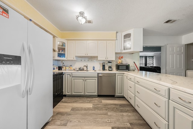 5407 Maltese Dr, Columbus, GA 31904 - kitchen featuring white refrigerator with ice dispenser, stainless steel dishwasher, electric range, light countertops, and a textured ceiling