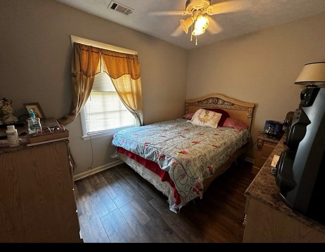 bedroom featuring baseboards, dark wood-style flooring, visible vents, and a ceiling fan