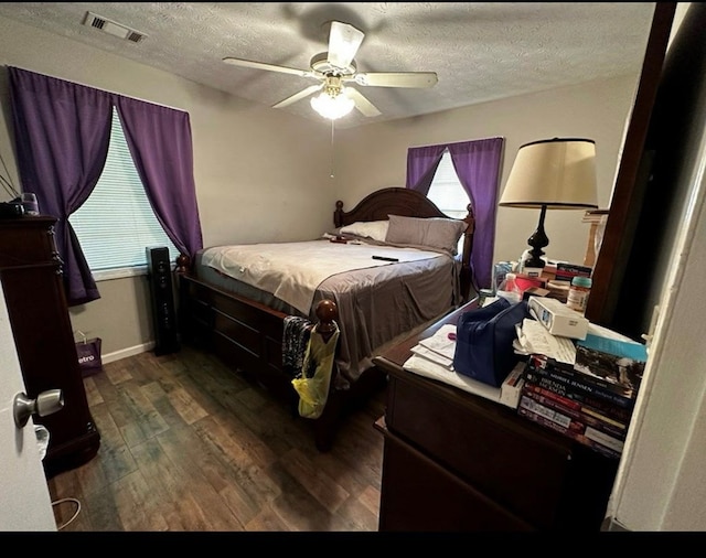 bedroom featuring visible vents, ceiling fan, a textured ceiling, and wood finished floors