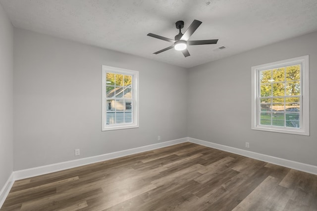 spare room featuring ceiling fan, dark hardwood / wood-style flooring, and a textured ceiling