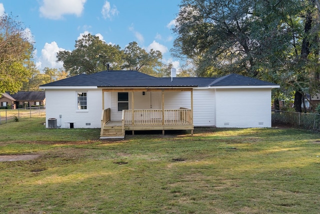 rear view of house with a deck, central AC unit, and a lawn