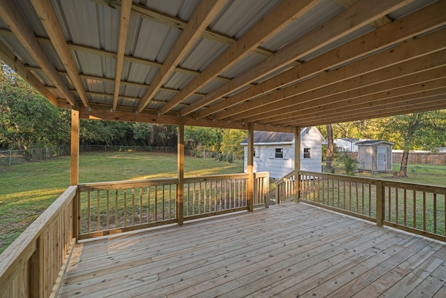 wooden terrace featuring a yard and a shed