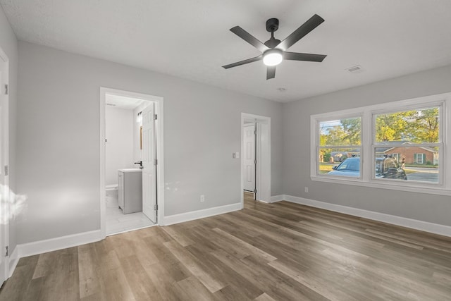 unfurnished bedroom with connected bathroom, ceiling fan, and wood-type flooring