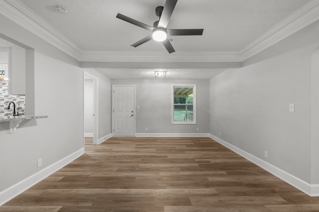 unfurnished room with wood-type flooring, a textured ceiling, and ornamental molding