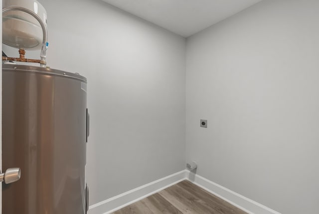 laundry room with electric dryer hookup, electric water heater, and hardwood / wood-style floors