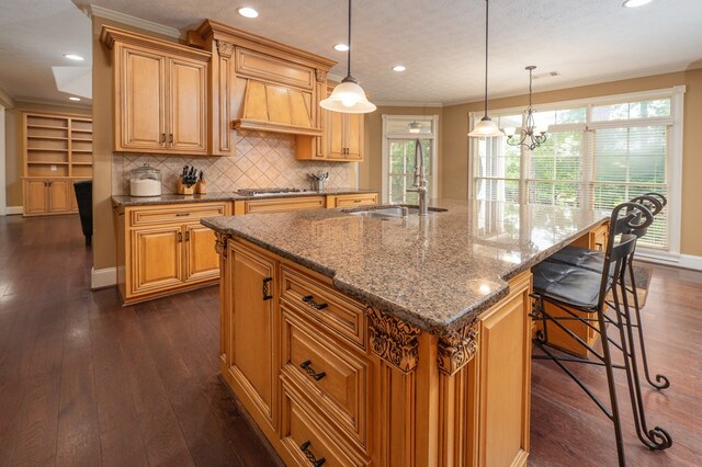 7036 Imperial Way, Columbus, GA 31904 - kitchen with dark wood-style floors, crown molding, dark stone counters, tasteful backsplash, and an island with sink