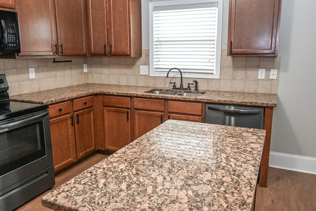 4447 Walking Stick Way, Columbus, GA 31907 - kitchen with appliances with stainless steel finishes, decorative backsplash, light stone countertops, wood finished floors, and brown cabinetry