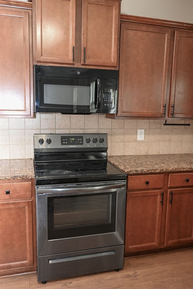4447 Walking Stick Way, Columbus, GA 31907 - kitchen with electric stove, black microwave, light wood finished floors, stone countertops, and decorative backsplash