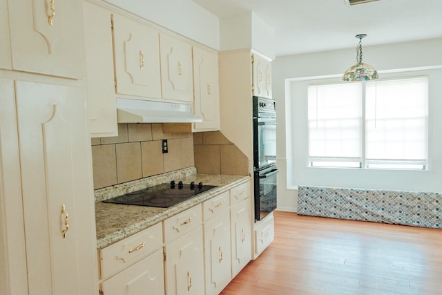 4814 20th Ave, Columbus, GA 31904 - kitchen featuring black appliances, under cabinet range hood, backsplash, light wood finished floors, and hanging light fixtures