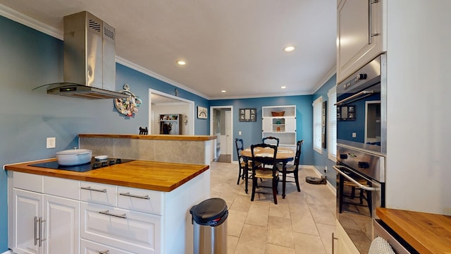 4042 Lyn Dr, Columbus, GA 31909 - kitchen with wood counters, island exhaust hood, black electric stovetop, oven, and recessed lighting