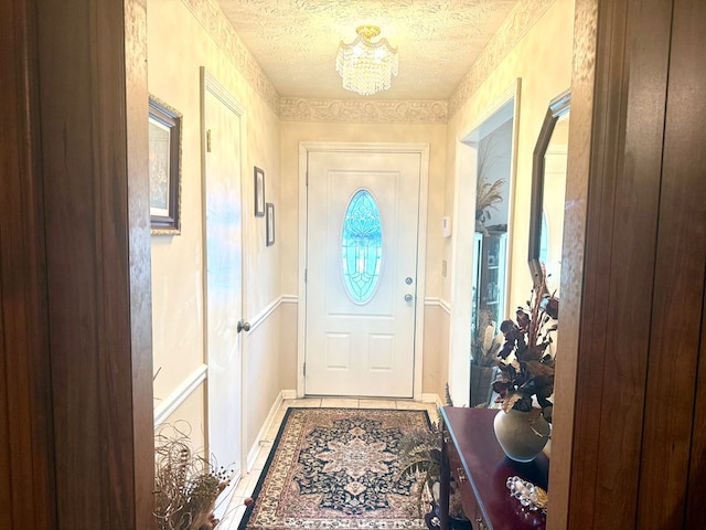 300 Jefferson Dr, Columbus, GA 31907 - doorway to outside featuring tile patterned floors, a chandelier, and a textured ceiling