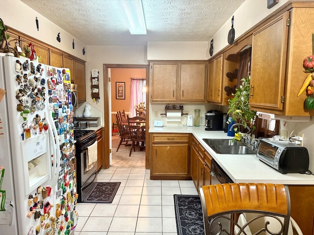 300 Jefferson Dr, Columbus, GA 31907 - kitchen featuring white refrigerator with ice dispenser, black gas range, light tile patterned floors, brown cabinetry, and light countertops