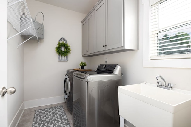 washroom with washer and dryer, cabinet space, baseboards, and light tile patterned floors