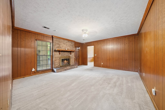 1818 Springvalley Dr, Columbus, GA 31904 - unfurnished living room featuring a textured ceiling, carpet floors, wooden walls, a fireplace, and ornamental molding