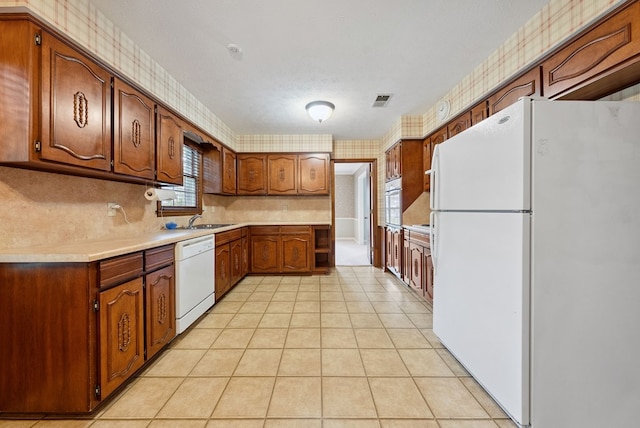 1818 Springvalley Dr, Columbus, GA 31904 - kitchen featuring white appliances, light countertops, brown cabinetry, light tile patterned floors, and wallpapered walls
