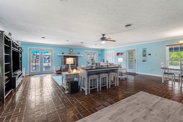 3264 Columbus Hwy, Box Springs, GA 31801 - living area featuring a textured ceiling, baseboards, crown molding, a ceiling fan, and brick patterned flooring