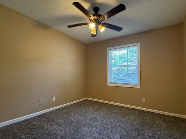 empty room with ceiling fan, baseboards, and dark colored carpet