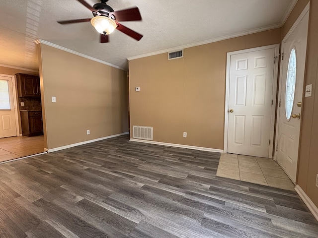 unfurnished living room featuring ceiling fan, wood finished floors, ornamental molding, a textured ceiling, and baseboards