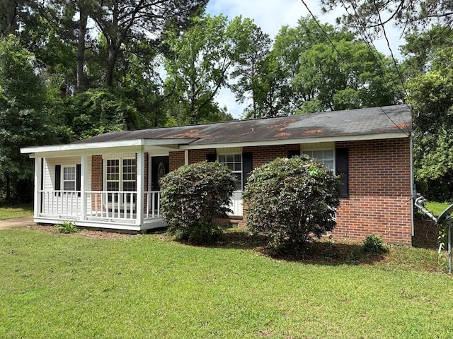 ranch-style house featuring a porch, a front yard, and brick siding