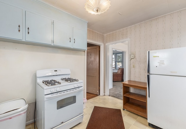 kitchen featuring light floors, white appliances, and wallpapered walls