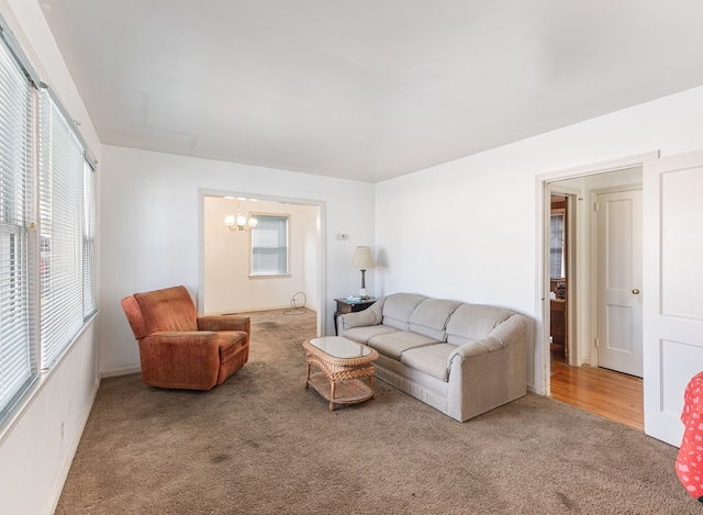 living room featuring a wealth of natural light, carpet flooring, and an inviting chandelier