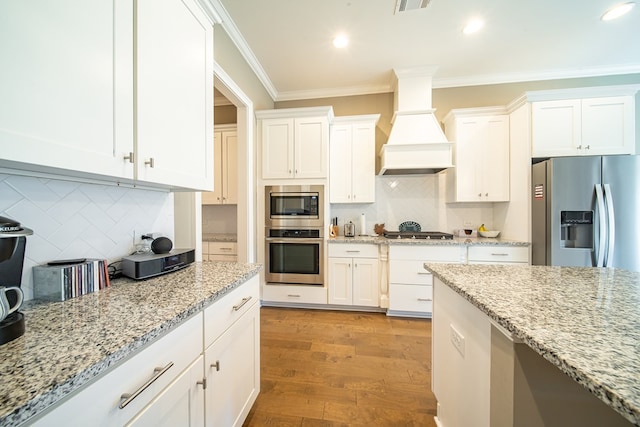 kitchen featuring custom exhaust hood, backsplash, stainless steel appliances, and ornamental molding