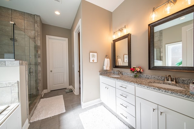 bathroom with a shower with door, tile patterned floors, and vanity