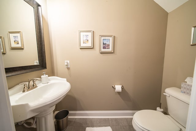 bathroom featuring sink, tile patterned floors, lofted ceiling, and toilet